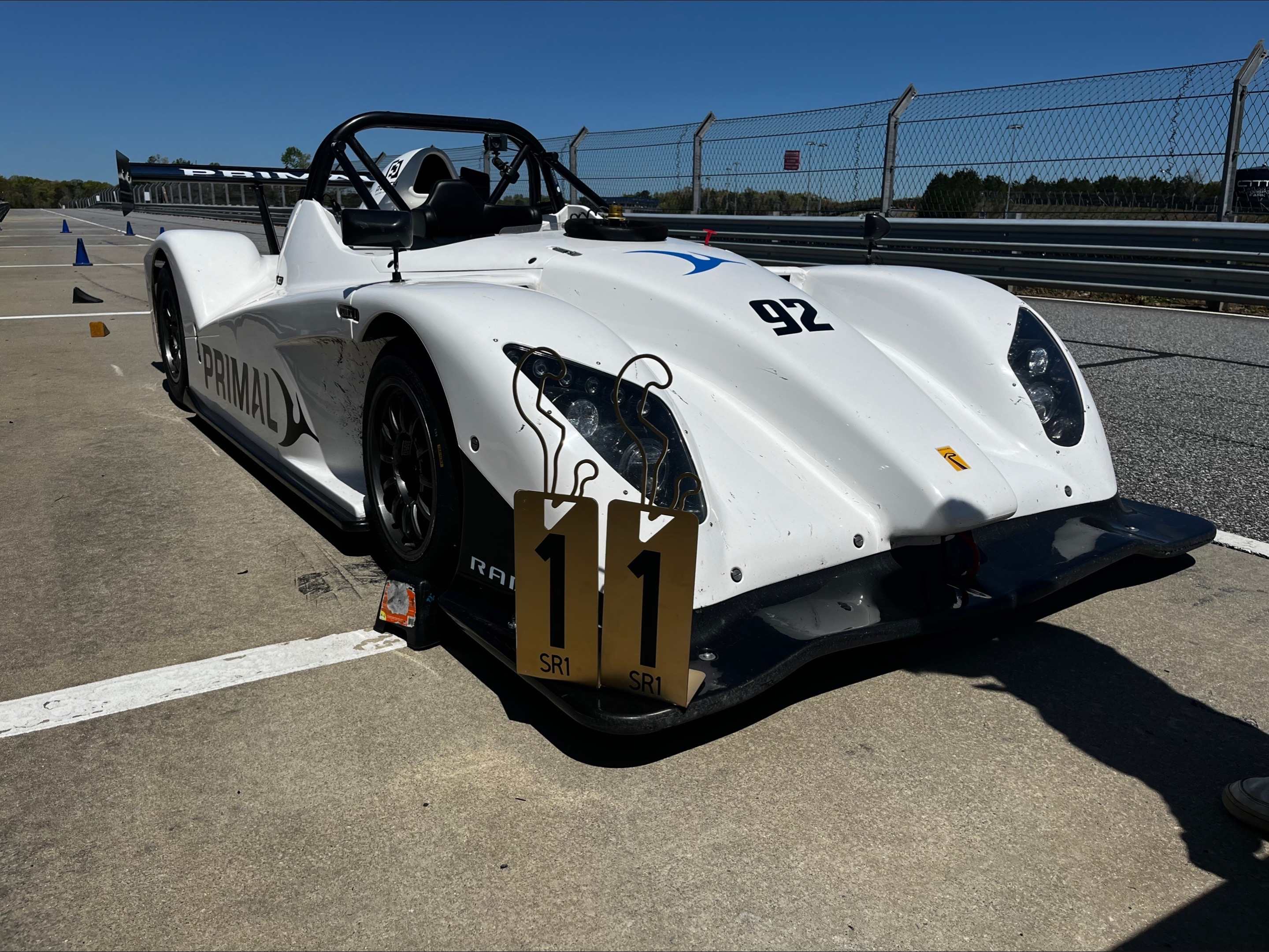The No. 92 Radical SR-1 parked in pit lane with grid number boards